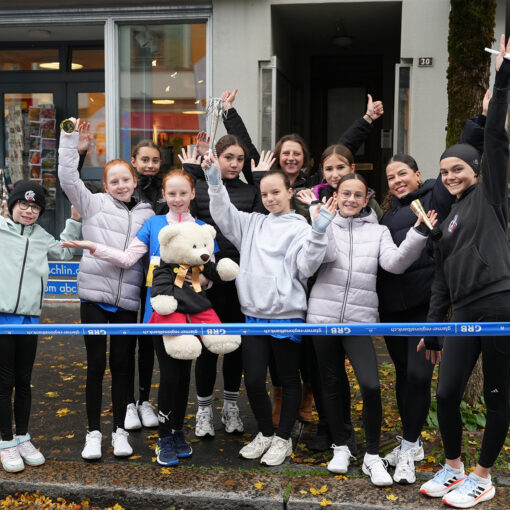 Gruppenfoto: Eisläuferinnen posieren mit den Händen in der Luft
