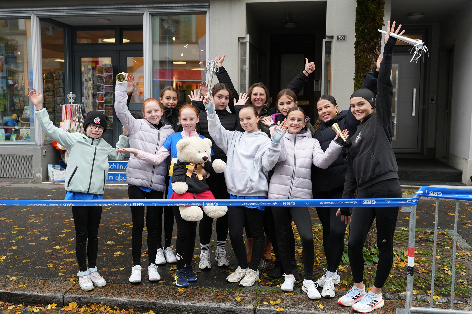 Gruppenfoto: Eisläuferinnen posieren mit den Händen in der Luft
